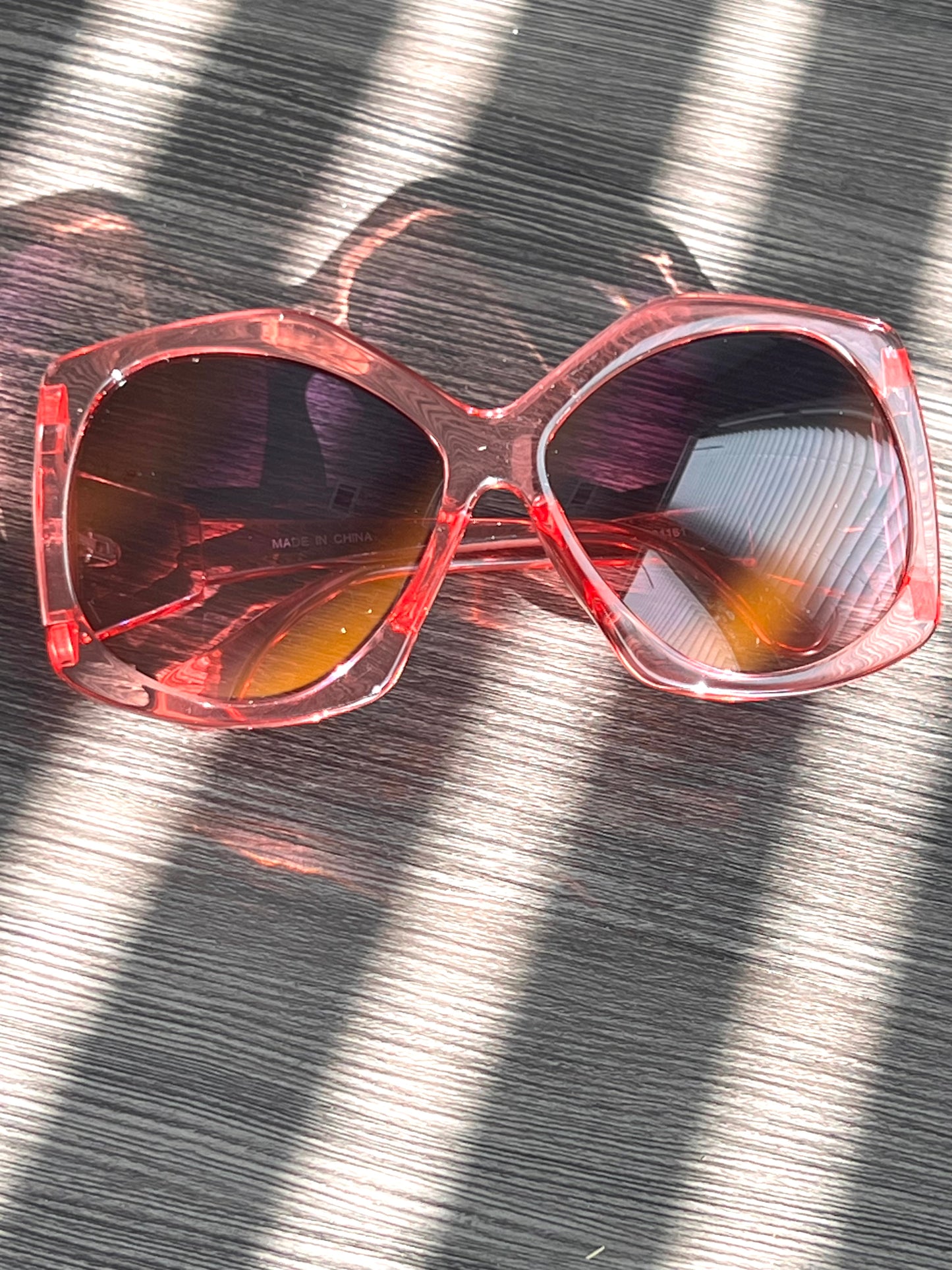 Bright pink oversized sunglasses with purple gradient lenses, playful and trendy statement eyewear